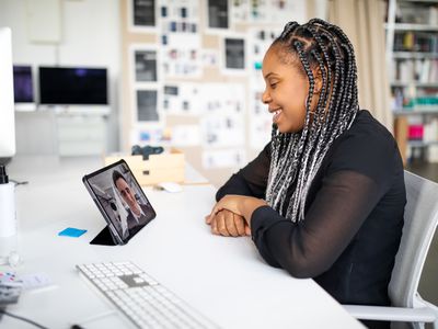 A woman multitasks with a video call on an iPad.