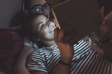 A couple using an iPad in bed