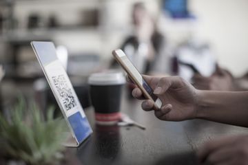 Hand holding smart phone, scanning barcode