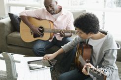 father and son playing guitars together