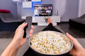 Trying to use an Apple TV remote with a bowl of popcorn.