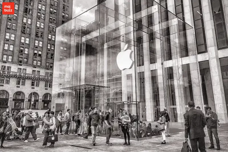 Many people standing under the Apple Office