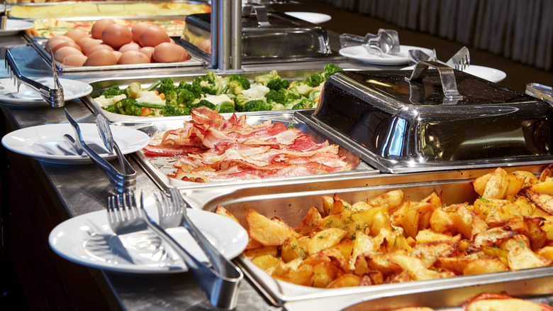 Buffet steam table with bacon, eggs, and vegetables