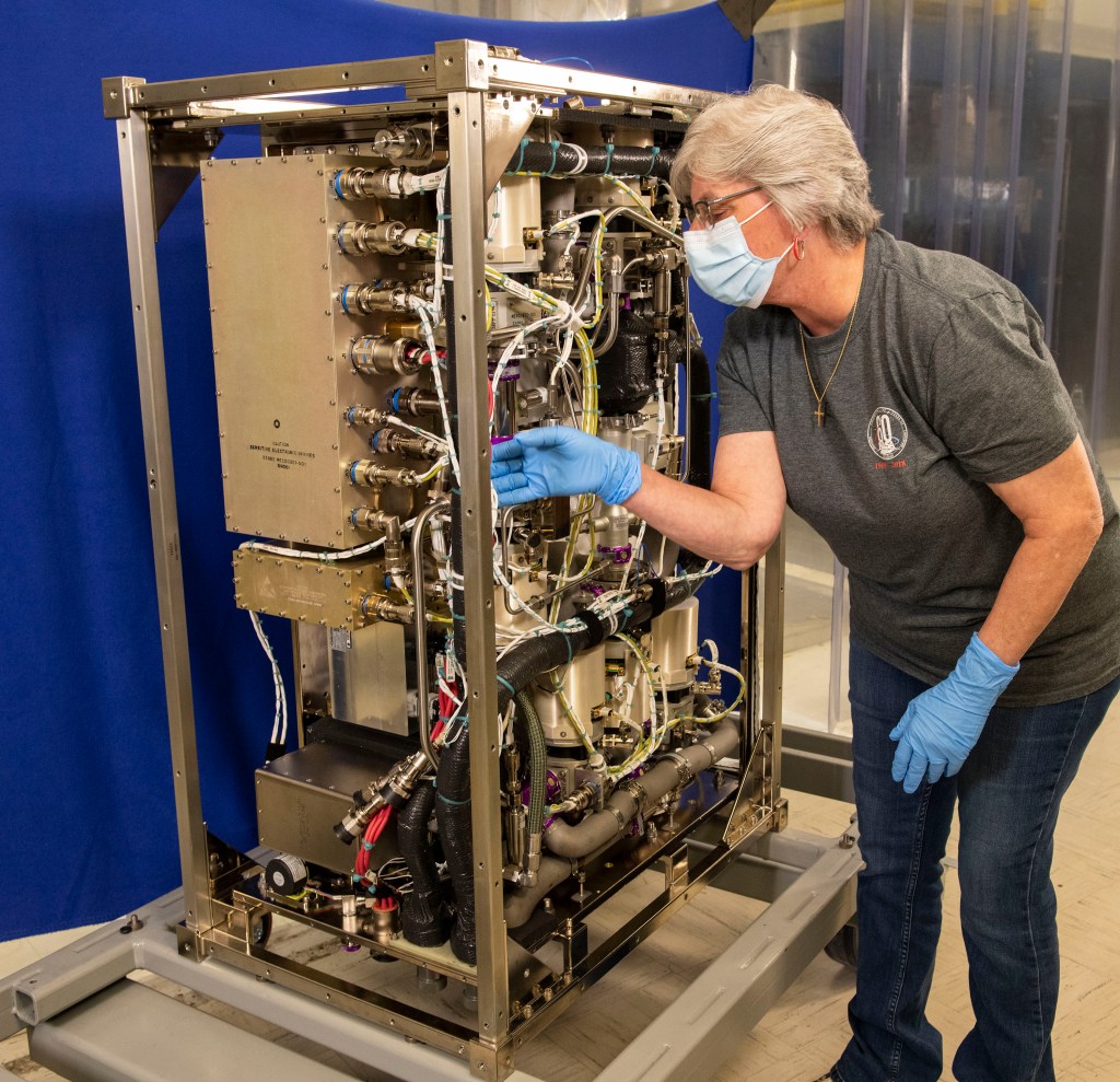 The new Four Bed Carbon Dioxide Scrubber is checked out by Kathi Lange.