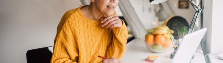 Smiling senior woman working on her computer at home