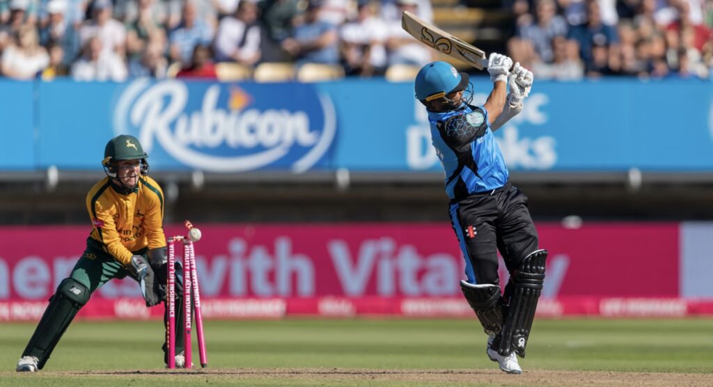 Cricket ball hitting stumps after batsman misses ball