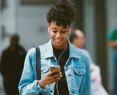 woman smiling at her phone, downloaded the Skrill app