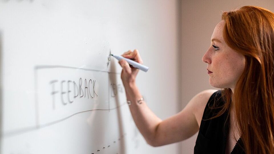 Frau beschreibt eine Whiteboard