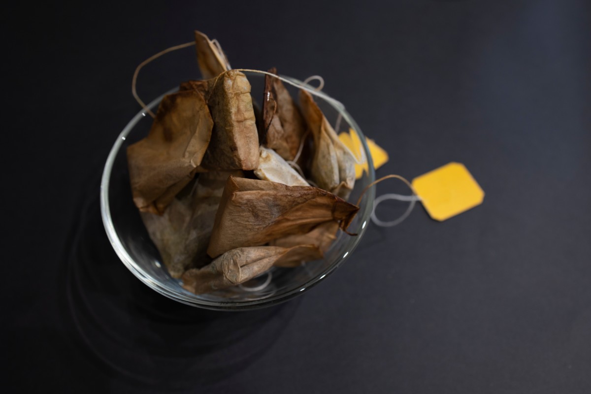 Used tea bags in a clear glass bowl. 