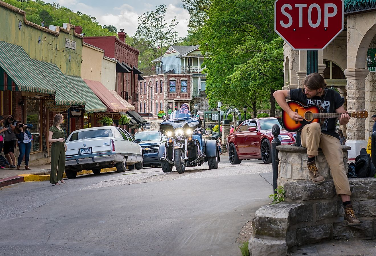 Motorcycle and guitar player in downtown Eureka Springs, Arkansas. Image credit shuttersv via Shutterstock