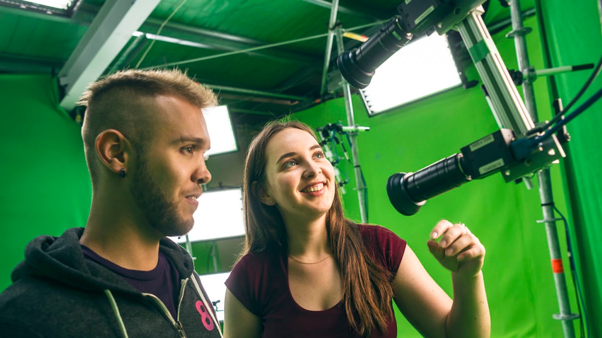 Two students looking at engineering devices in studio set-up.