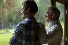 Thoughtful father and son looking out a window