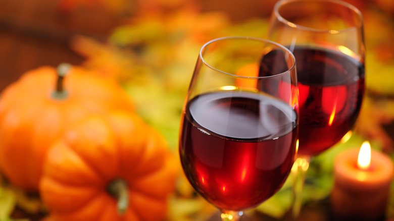 pumpkins with two glasses of red wine and a candle