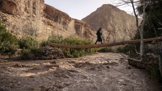 A father and child in Morocco cross the Dades River, swollen after heavy rain