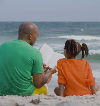 Man reading book to his child