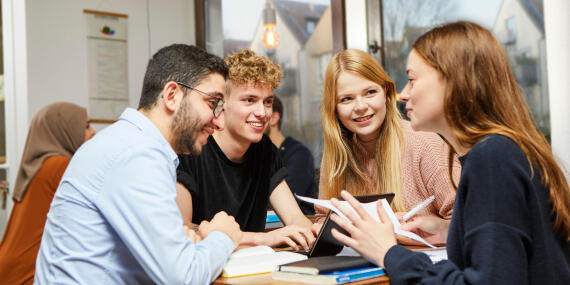 Gruppe von Studierenden an einem Tisch sitzend