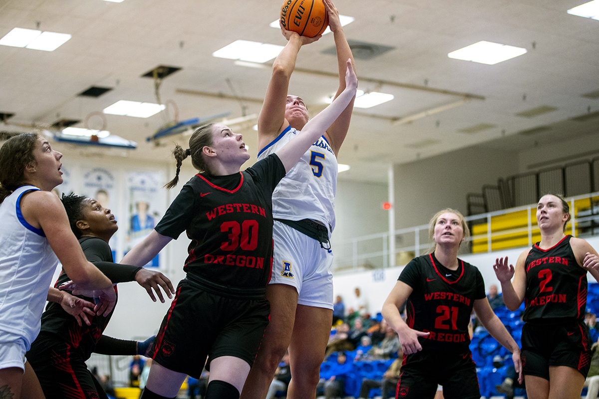 A UAF Women's Basketball player attempts to score points as a Western Oregon player tries to block her throw during a game on Jan. 27, 2024.