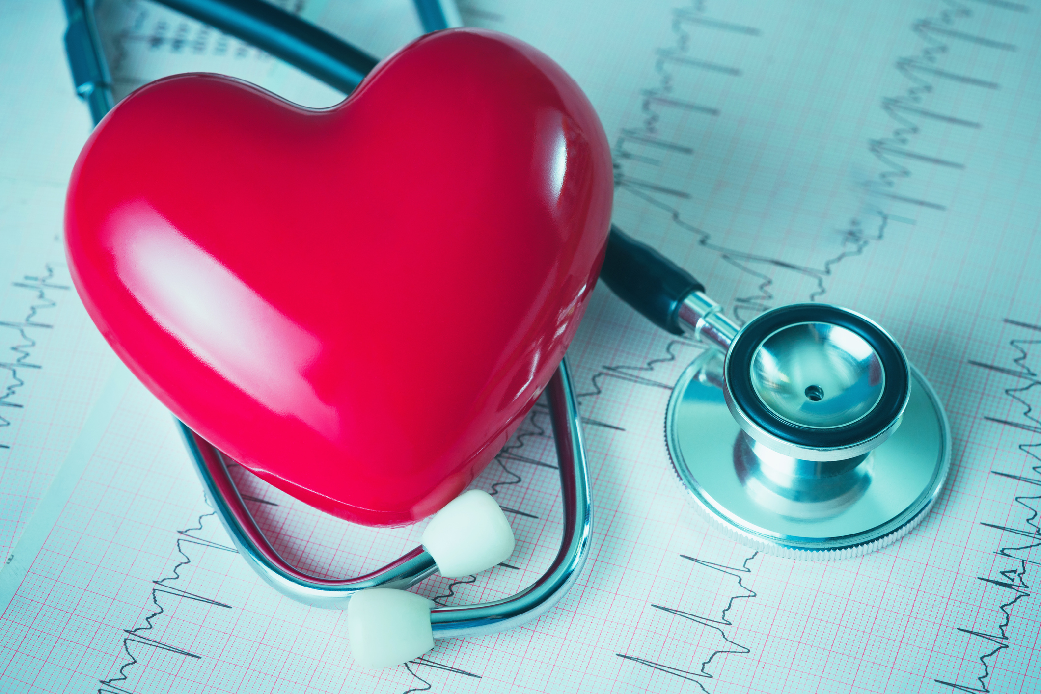 Photo of a stethoscope and heart-shaped stress reliever on top of an echocardiogram chart.