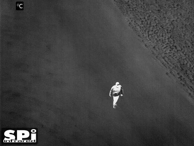 FLIR clip on image of a man walking up a deserted road