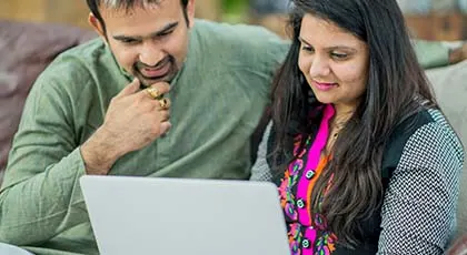 Middle aged couple working on a computer at home