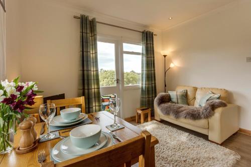 LeckmelmLoch Broom Cabins Seaviews& Petfriendly的客厅配有桌子和沙发