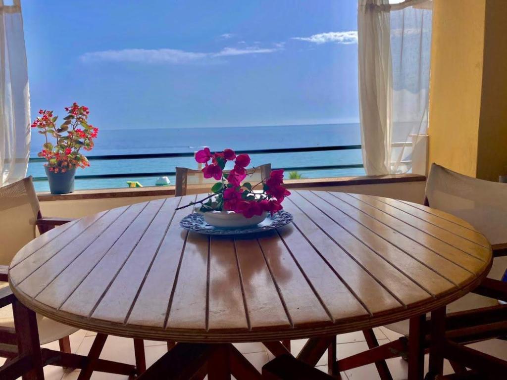 格利法达Corfu Glyfada Beach Apartment 91的一张木桌,上面有花瓶