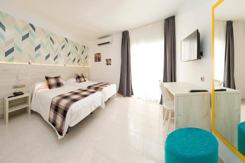 伊维萨镇Hotel Vibra Lei Ibiza - Adults only的配有一张床和一张书桌的酒店客房