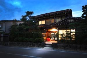 高山Ichinomatsu Japanese Modern Hotel的夜晚有灯的日式房子