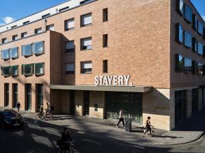 科隆STAYERY Cologne Ehrenfeld的建筑的 ⁇ 染,人们在建筑前面行走