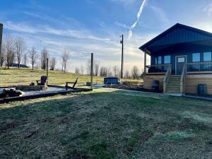 劳伦斯堡Bourbon Barrel Cottages #1 of 5 on Kentucky trail的田野旁的小房子