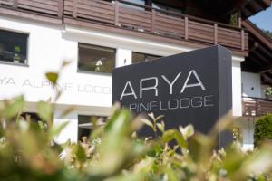 塞尔瓦迪加尔代纳山谷Arya Alpine Lodge的建筑前的阿诺瓦松小屋标志