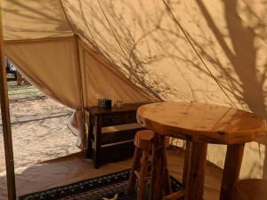 摩押Moab Glamping Setup Tent in RV Park #6 OK-T6的一个带木桌和木凳的帐篷