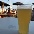 Checked in at Shelter Hall Raw. Having a beer on the beach — with Jessica