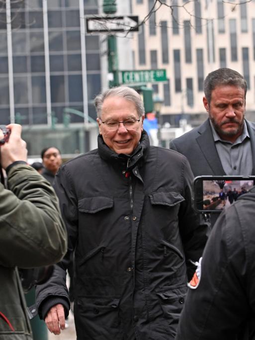 Der ehemalige NRA-Vorsitzende LaPierre geht umringt von Medienvertretern und Polizisten über eine Straße in Manhattan.