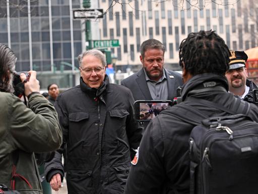 Der ehemalige NRA-Vorsitzende LaPierre geht umringt von Medienvertretern und Polizisten über eine Straße in Manhattan.