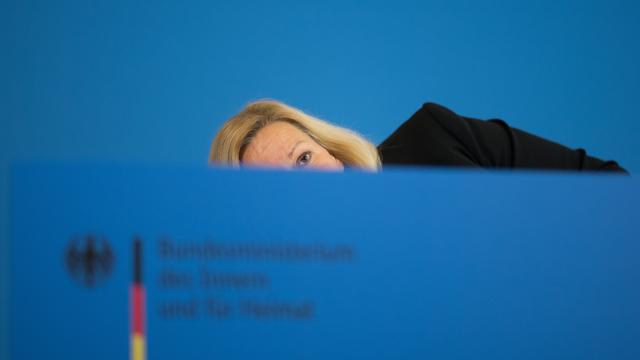 Nancy Faeser (SPD), Bundesministerin für Inneres und Heimat, bückt sich nach einer Pressekonferenz zur Bekämpfung der Organisierten Kriminalität und zur Änderung des Sprengstoffgesetzes, um ihre Krücken aufzuheben.