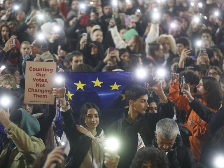 Menschen nehmen an einer Kundgebung der Opposition teil vor dem Parlamentsgebäude im Zentrum von Tbilisi.