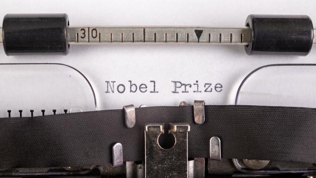 Die Worte Nobel und Prize, getippt auf ein Blatt Papier, das in eine Schreibmaschine eingespannt ist.