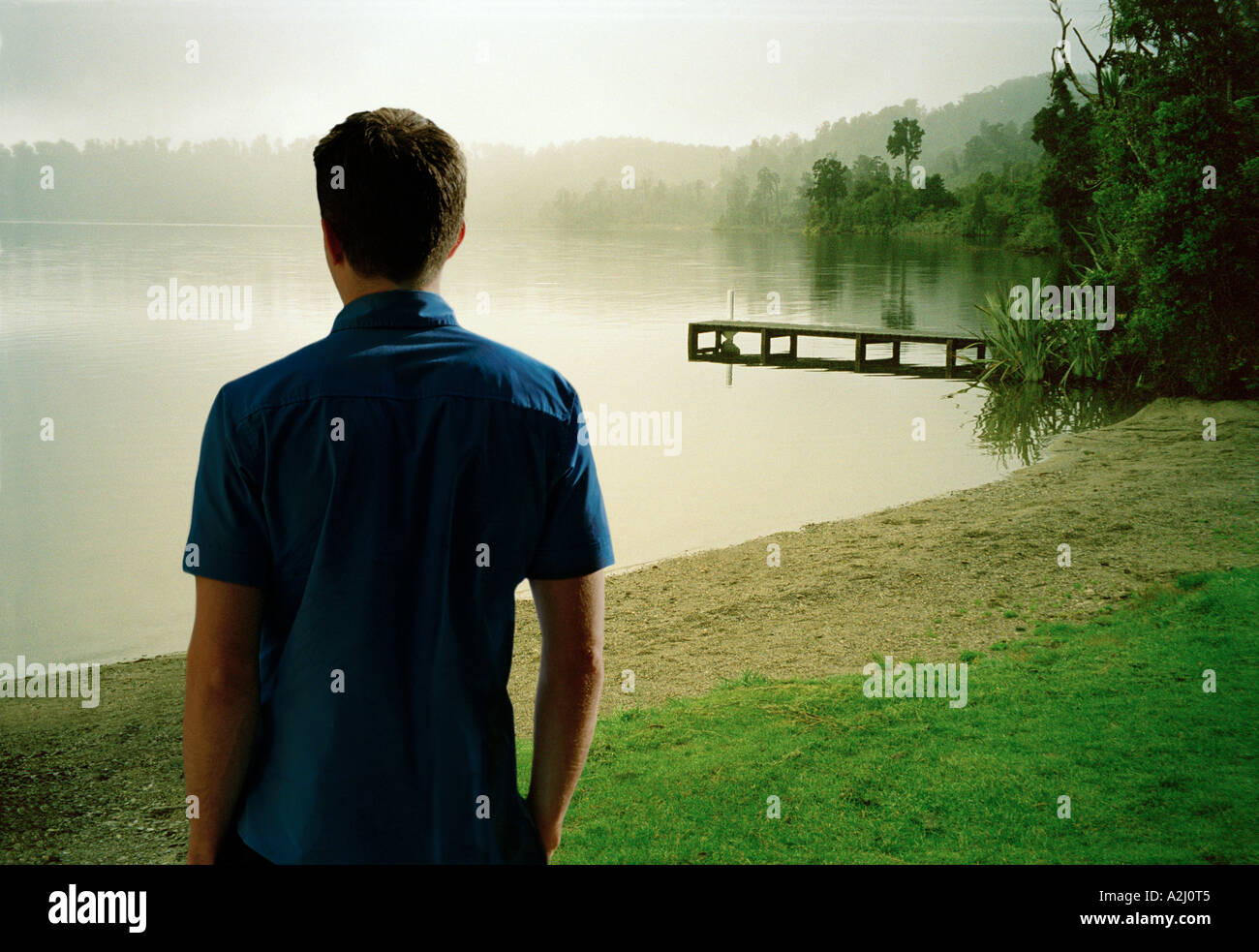 Man looking across a lake. Stock Photo