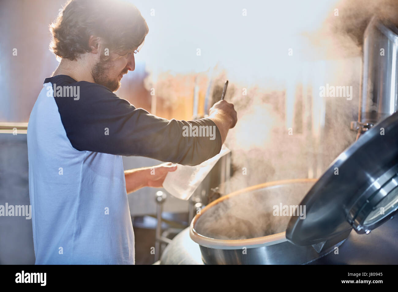 Male coffee roaster at tank Stock Photo