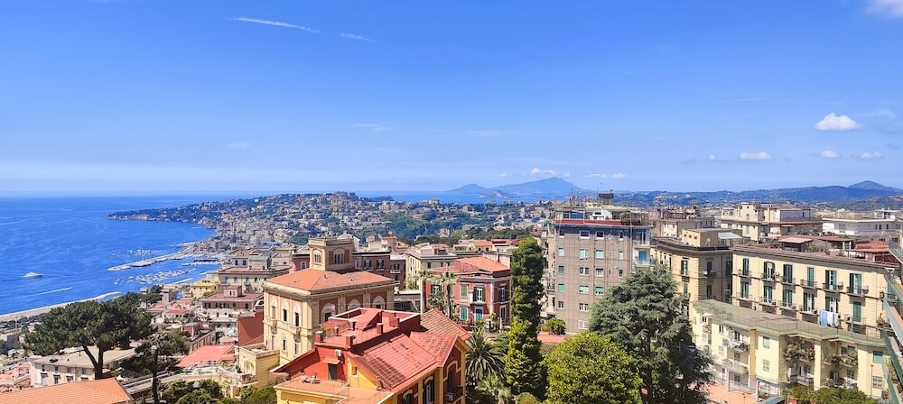 Bay of Naples with colourful rooftops and a bright blue sky