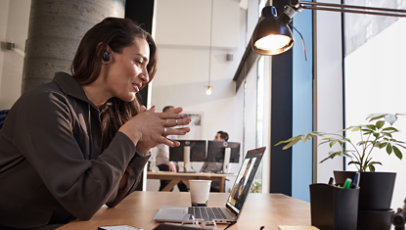 A woman sitting at a table and taking a video call