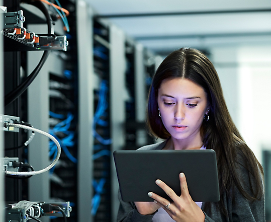 Woman holding tablet and standing in front of servers