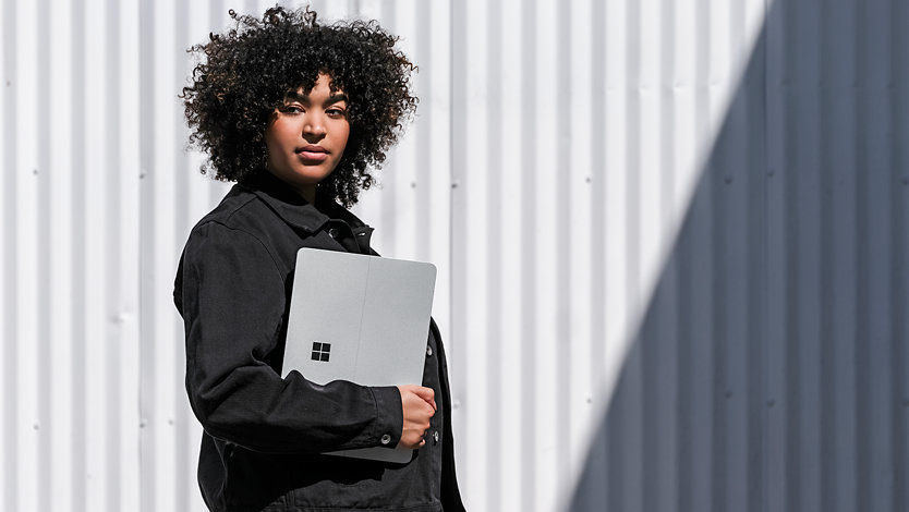 Eine junge Frau mit einem Surface Laptop 3. 