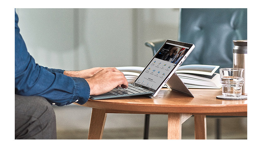 A person signing in on their Surface tablet on a coffee table