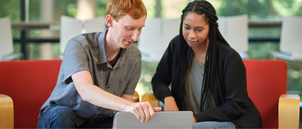 Two people looking at a laptop.