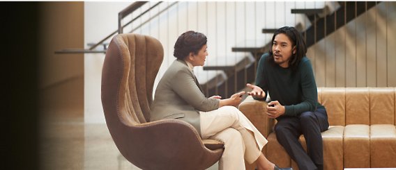 A person and another person sitting in a chair