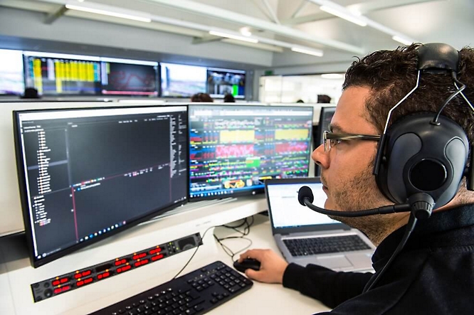 A person working on computer with multiple monitors