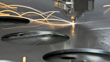 CNC laser skipping across a metal surface, leaving light trails in long exposure.