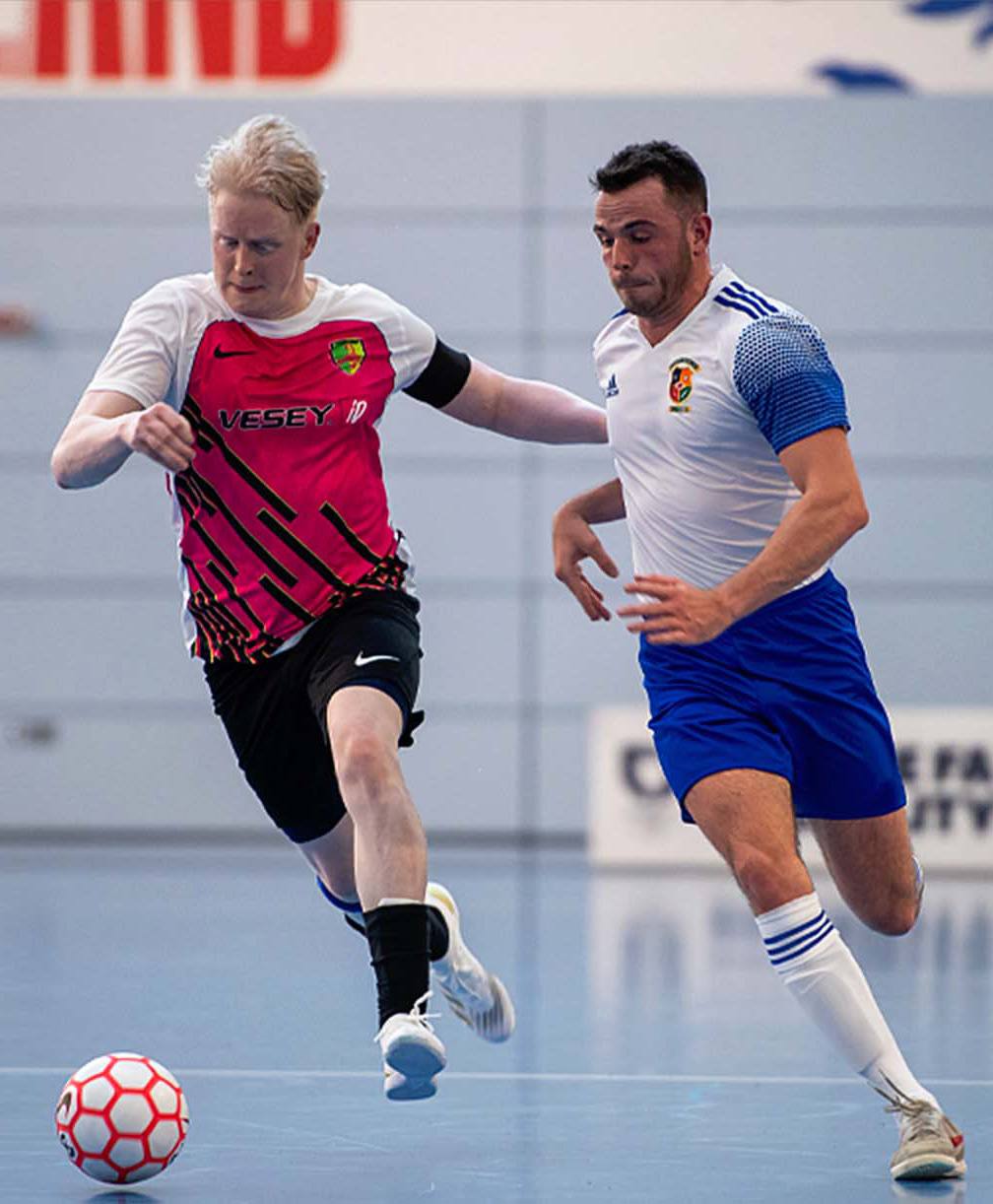 Two players chasing the ball during a futsal match